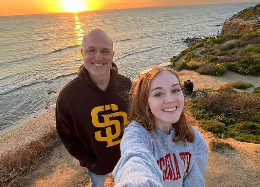 A man and woman taking a selfie at sunset.