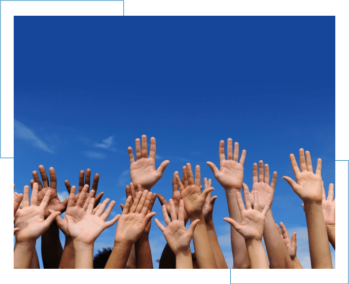 A group of people raising their hands in the air.