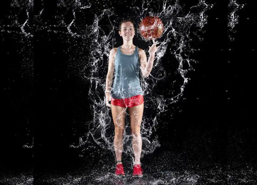 A woman holding a football in the water.