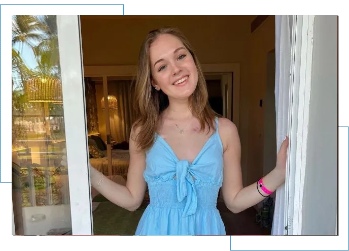 A girl in blue dress standing at the door.