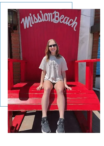 A woman sitting on top of a giant red chair.